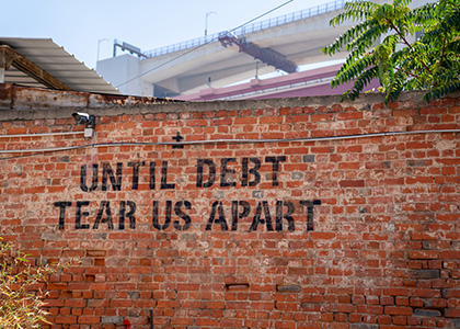 Brick wall that says "Until Debt Tear Us Apart."